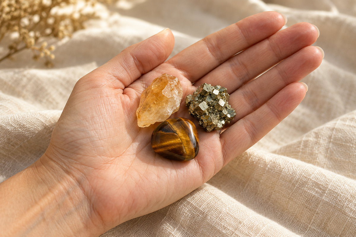 Citrine, pyrite et œil de tigre réunis dans la paume d’une main